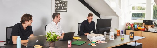 The three co-founders at the Social Supermarket office with social enterprise products on the desks